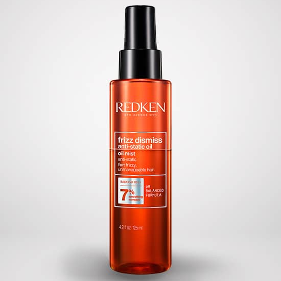 Redken hair oil bottle on a light gray background