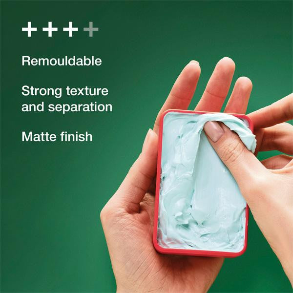 Hand holding a red container with green substance, against a green background with text about product features.