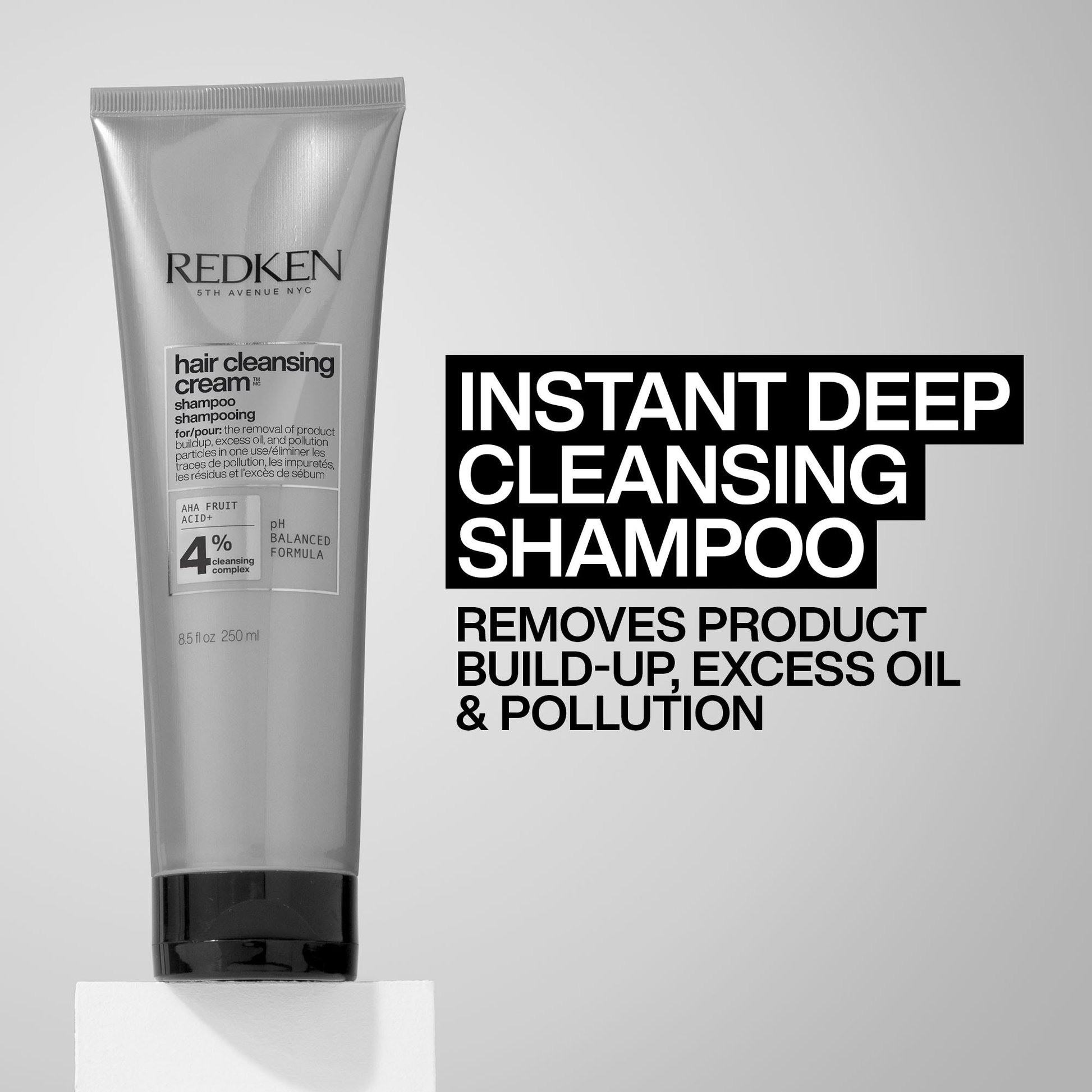 Redken Instant Deep Cleansing Shampoo tube on a gray background with text.