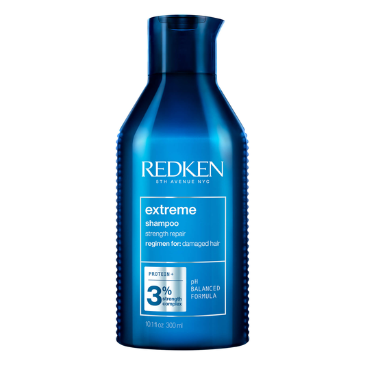 Blue bottle of Redken extreme shampoo on a white background