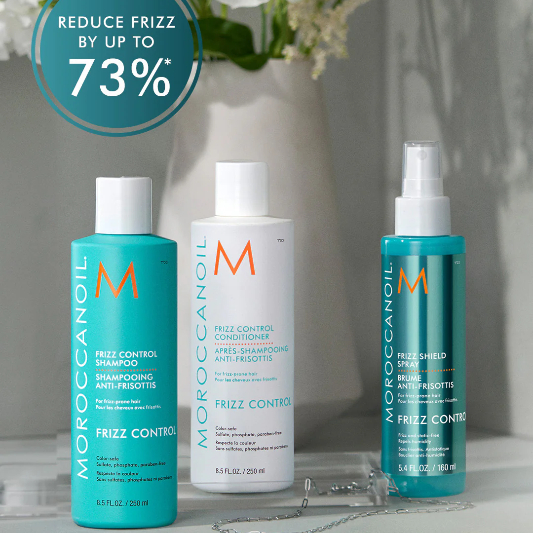 Moroccanoil hair care products with a decorative vase and flowers in the background
