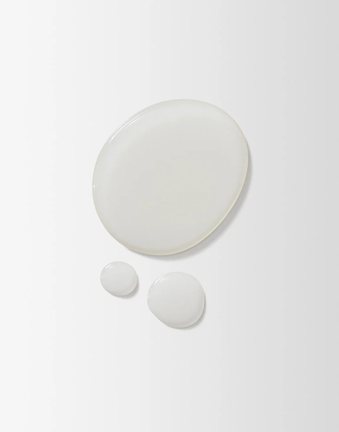 Set of three white ceramic plates on a light gray background
