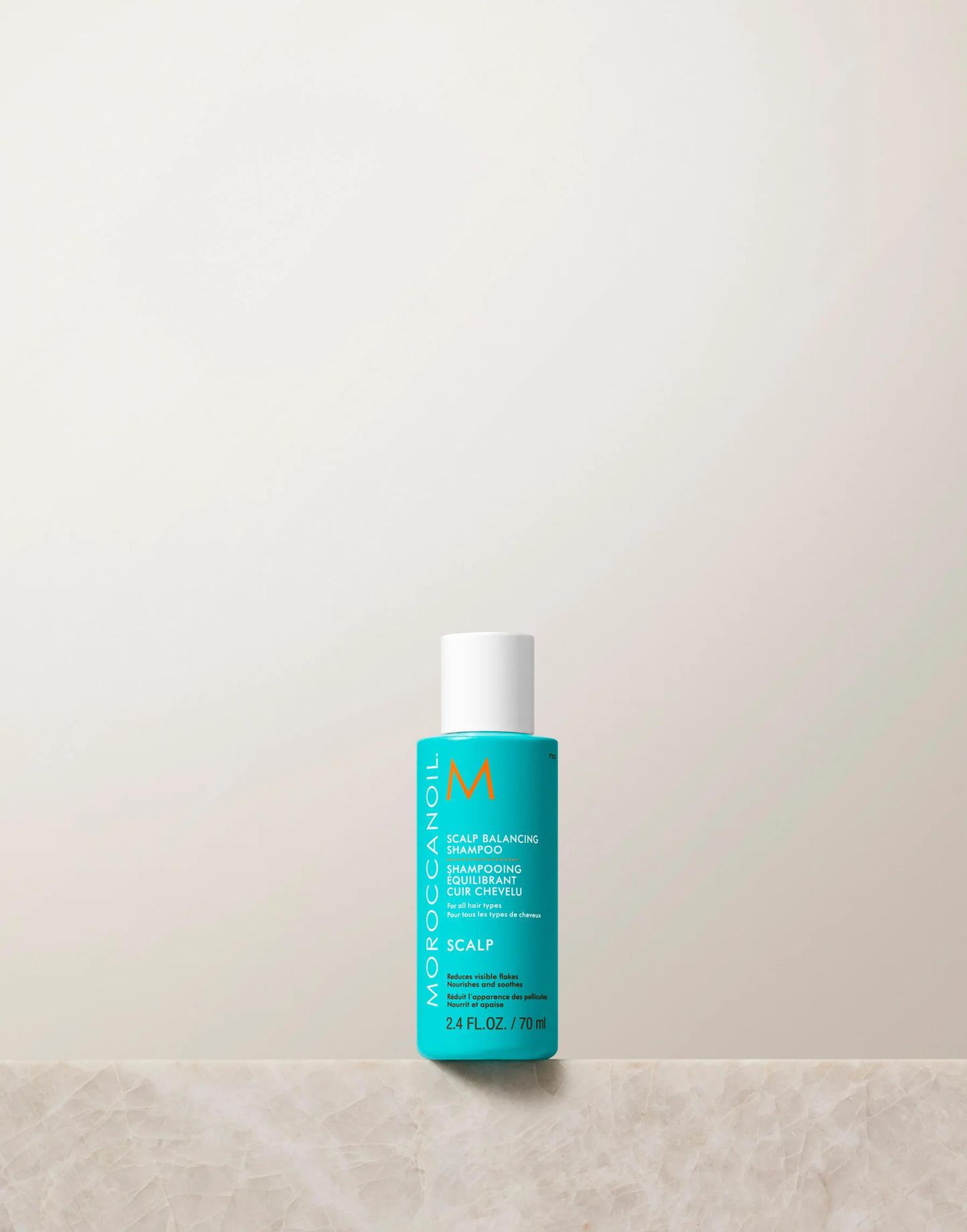Moroccanoil bottle on a light beige background