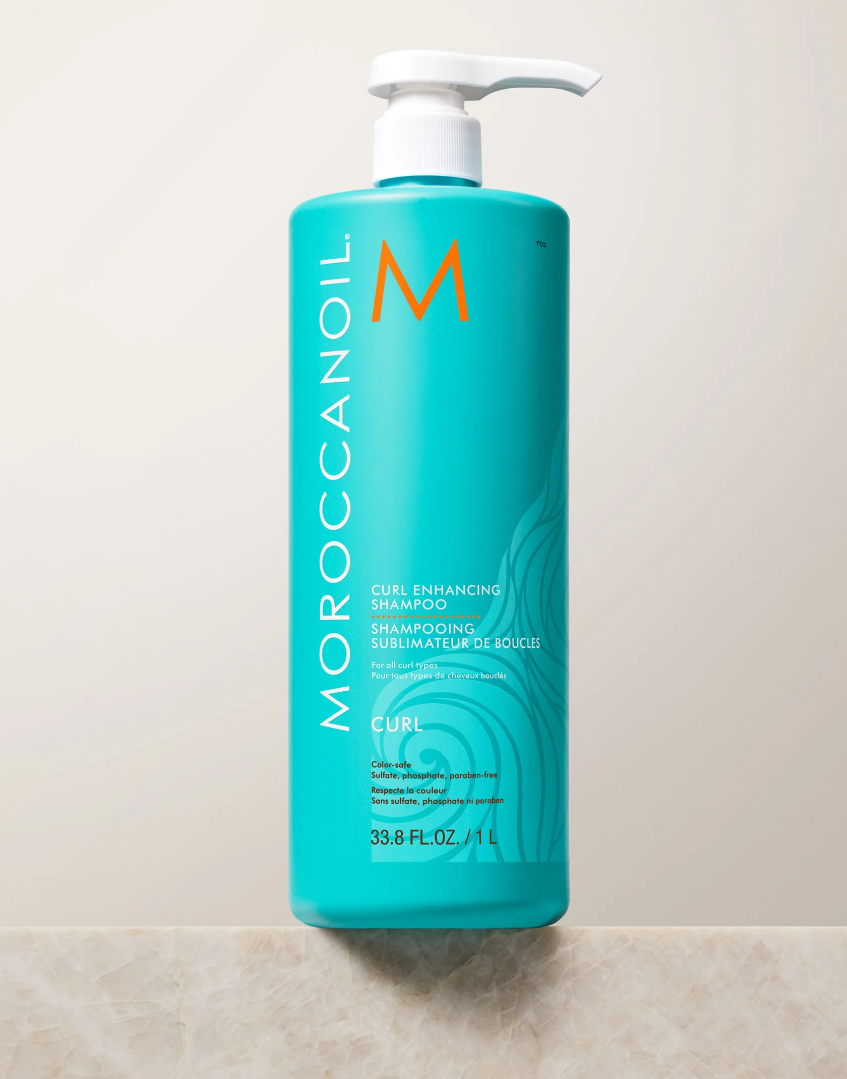 Moroccanoil bottle of shampoo on a tiled bathroom floor