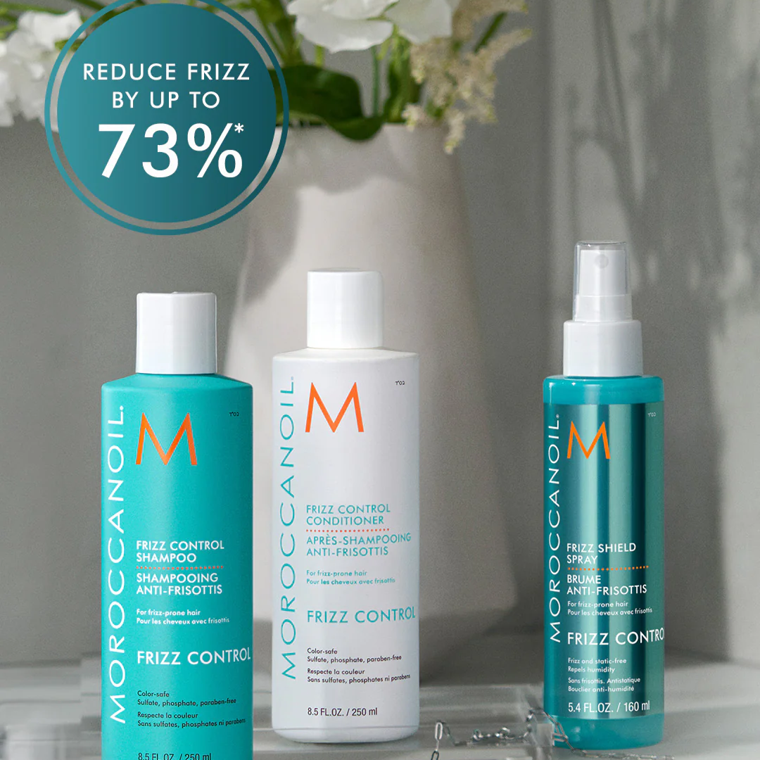 Moroccanoil hair care products with a decorative vase and flowers in the background