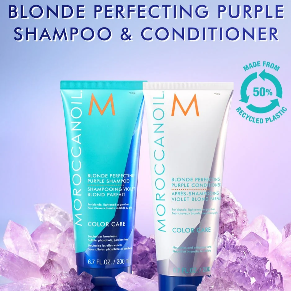 Moroccanoil Blonde Perfecting Purple Shampoo and Conditioner bottles with purple crystals on a light blue background