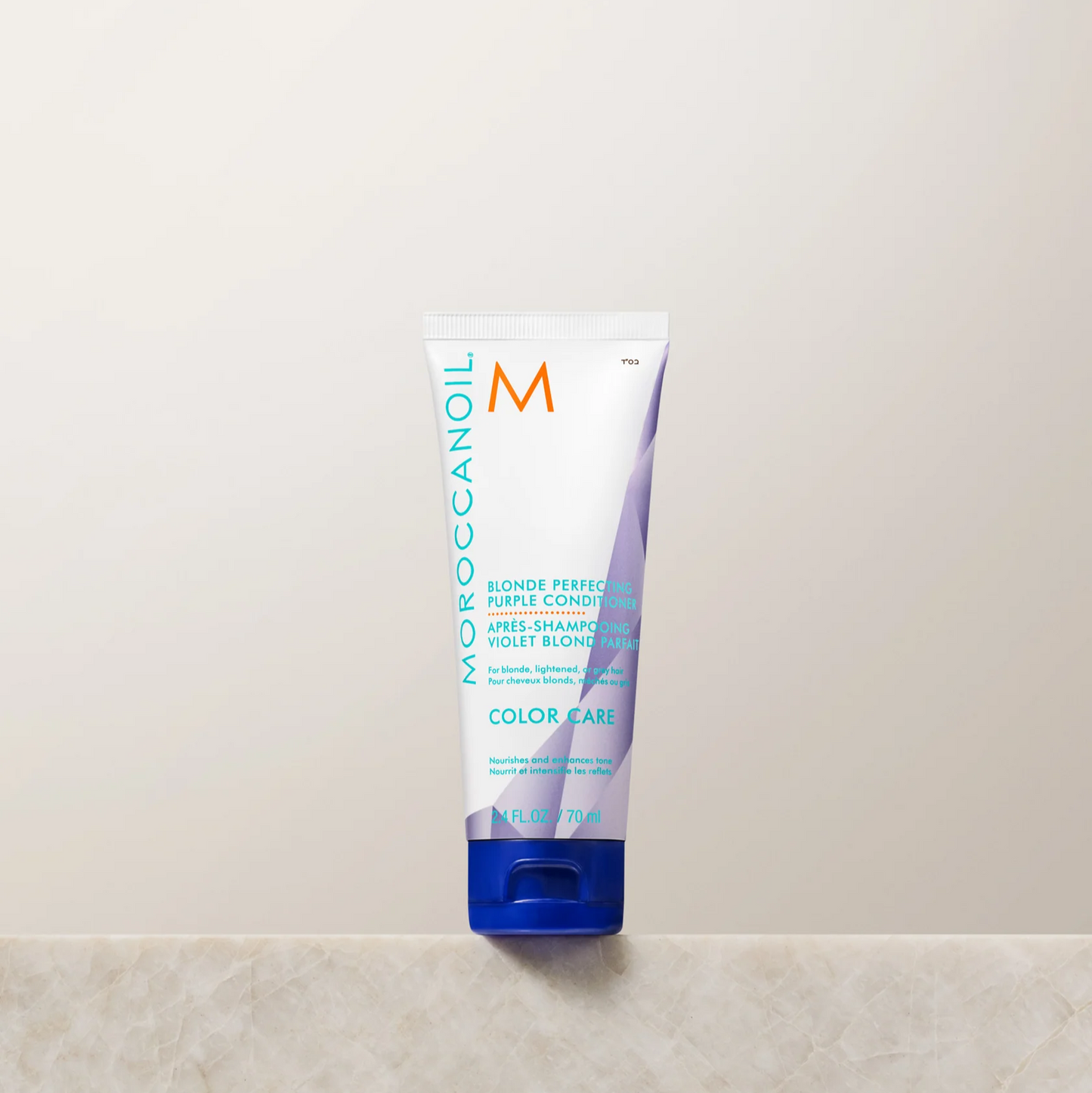 Moroccanoil conditioner tube on a light beige surface