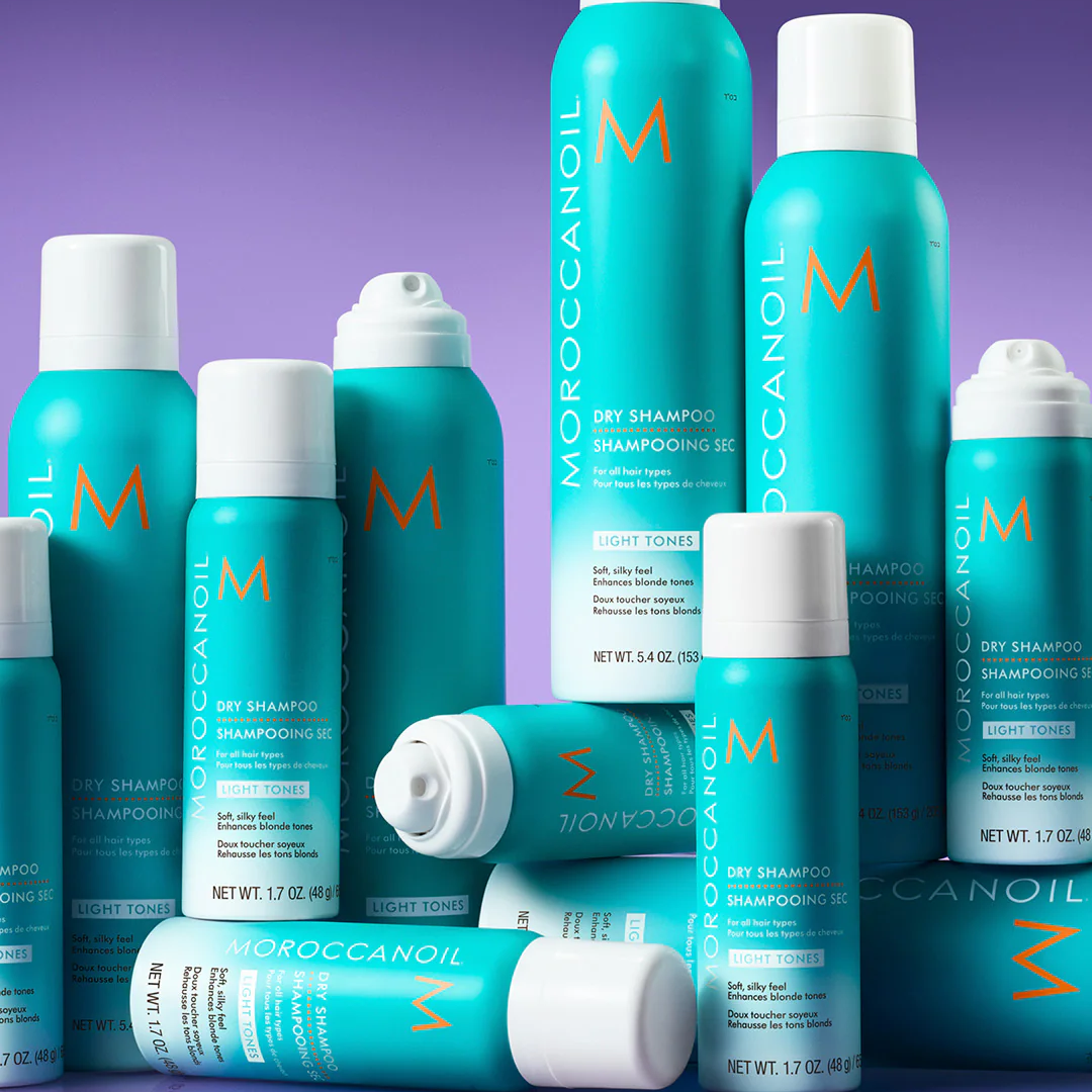Collection of Moroccanoil hair care products on a purple background