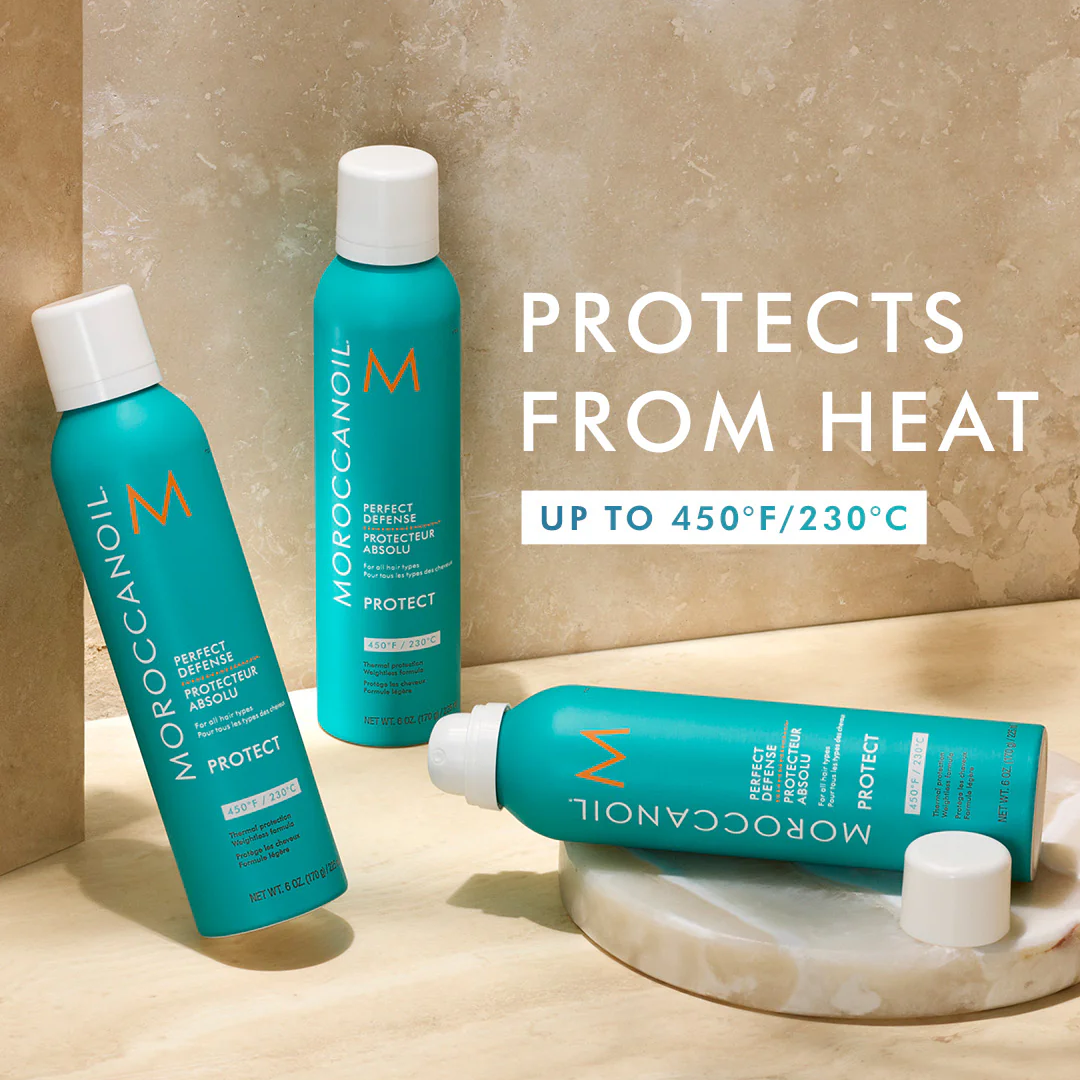 Moroccanoil hair care products on a marble surface with text about heat protection.