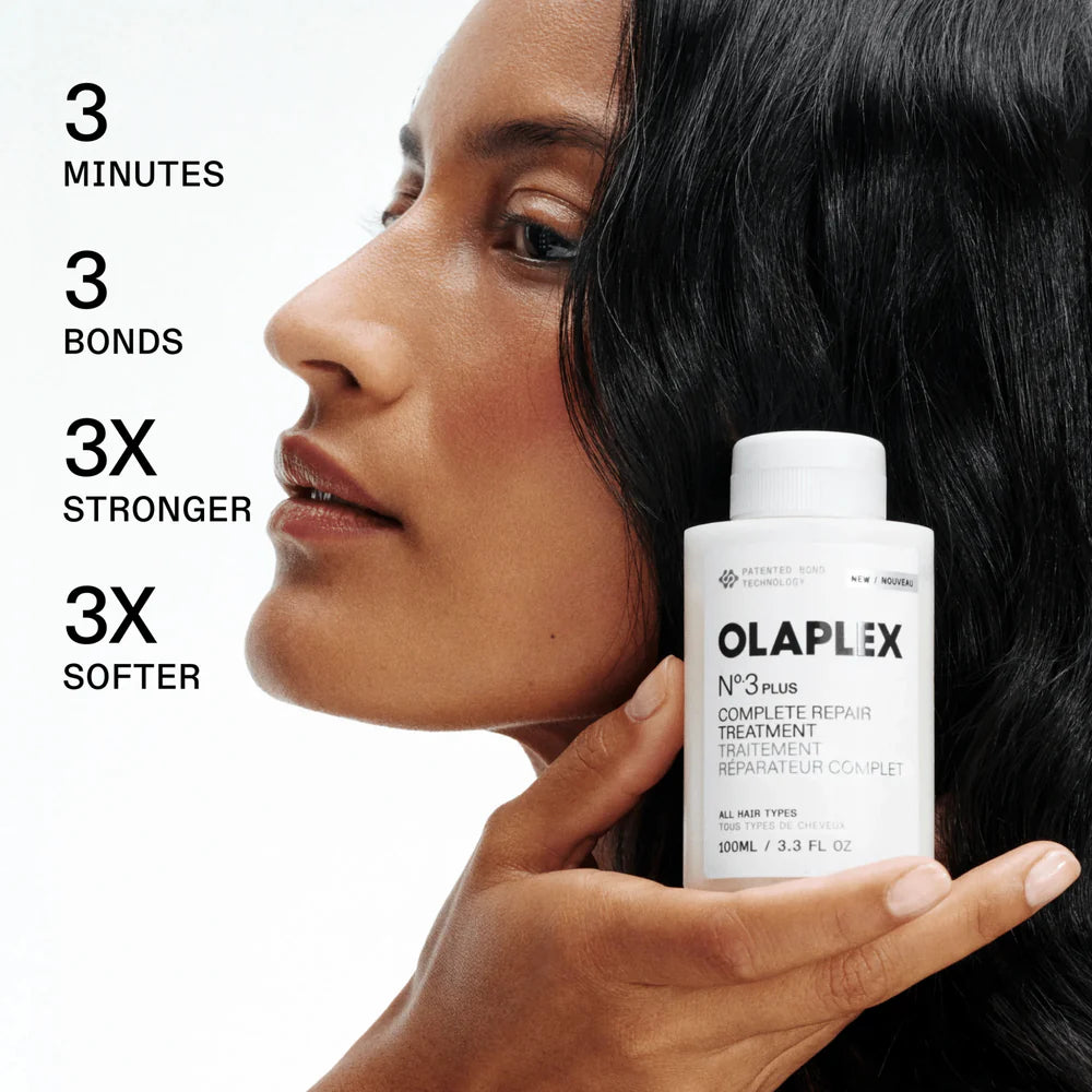 Woman holding an Olaplex hair treatment bottle with product benefits text on a white background