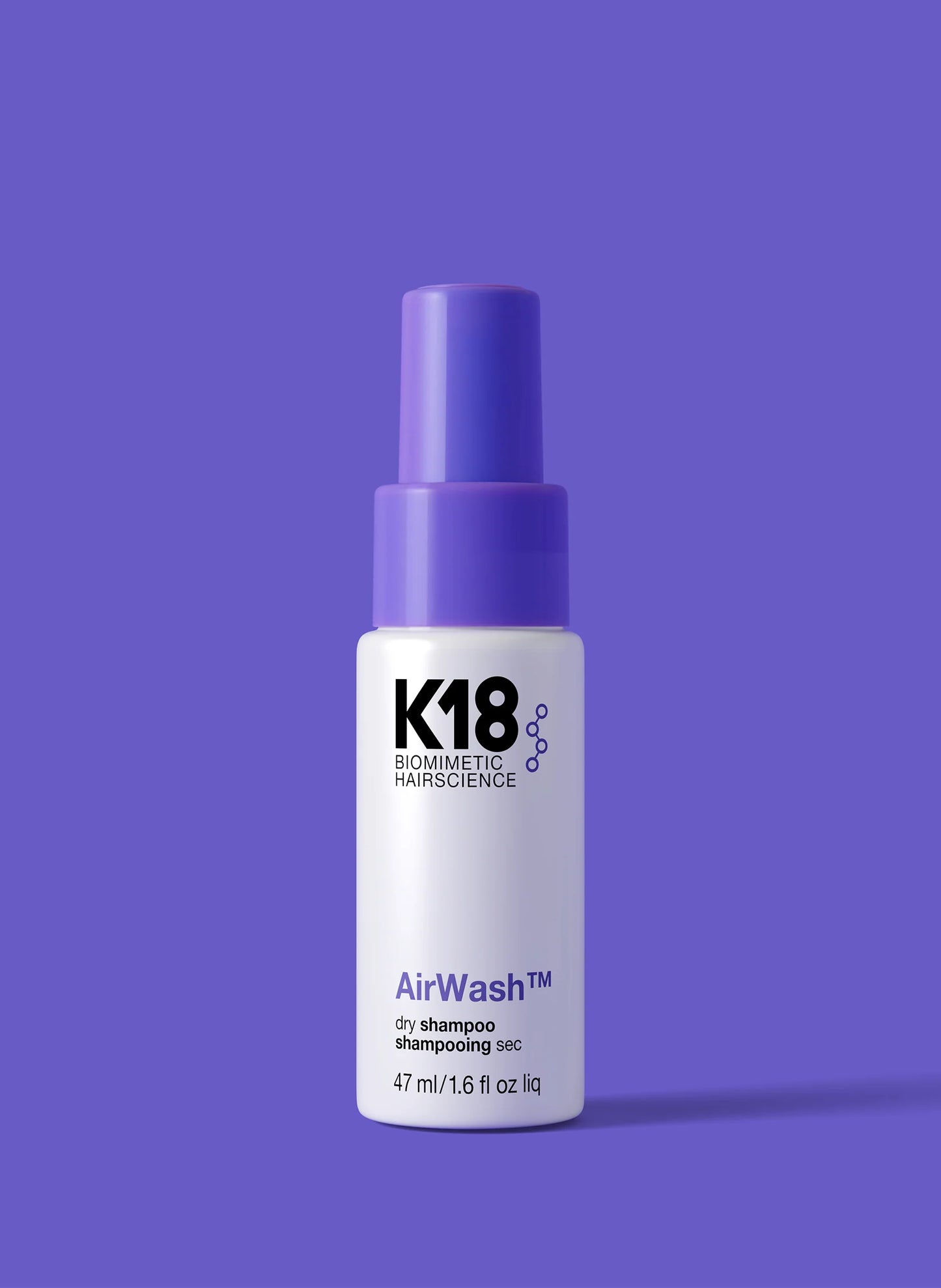K18 AirWash dry shampoo bottle on a purple background