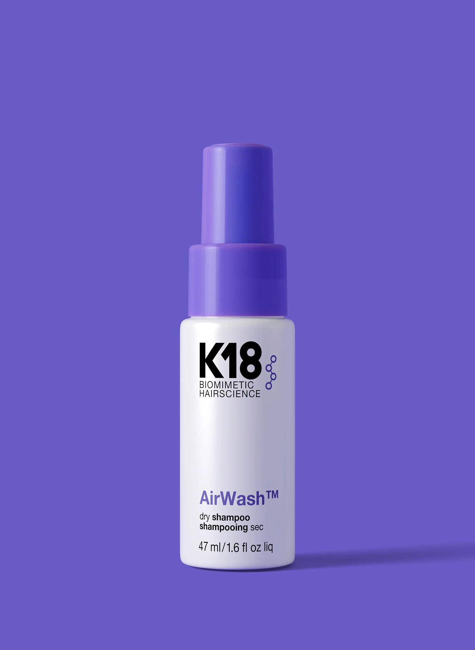 K18 AirWash dry shampoo bottle on a purple background