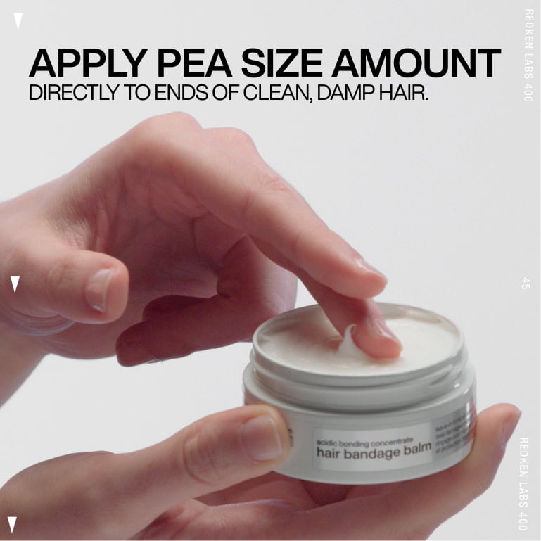 Hand applying a pea-sized amount of hair balm from a jar.