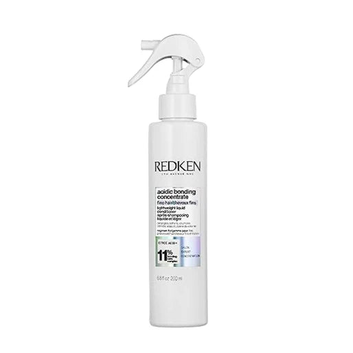Redken hair product bottle with spray nozzle on a white background