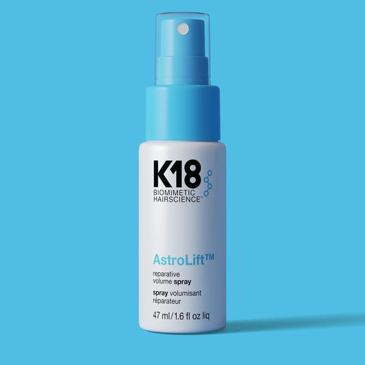 K18 AstroLift hair spray bottle on a blue background