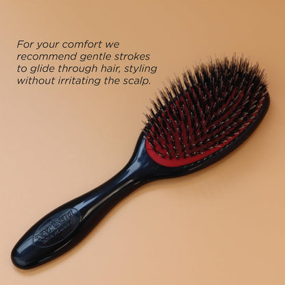 Black large hairbrush with red cushion on a beige background
