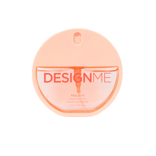 A round, translucent peach-colored perfume bottle labeled 'DESIGNME HOLD ME' on a solid white background.