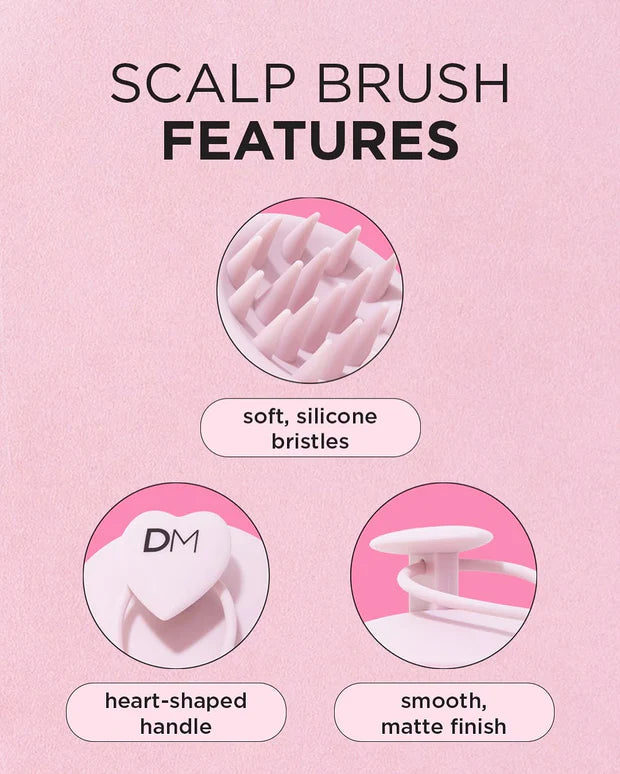 Scalp brush features with soft silicone bristles, heart-shaped handle, and smooth matte finish on a pink background.