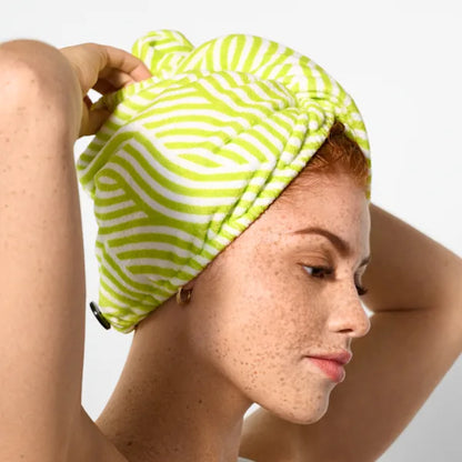 Person wearing a green and white striped towel on their head against a plain background