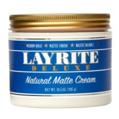 A jar of Layrite Deluxe Natural Matte Cream hair product with a blue label and gold lid, shown against a white background.