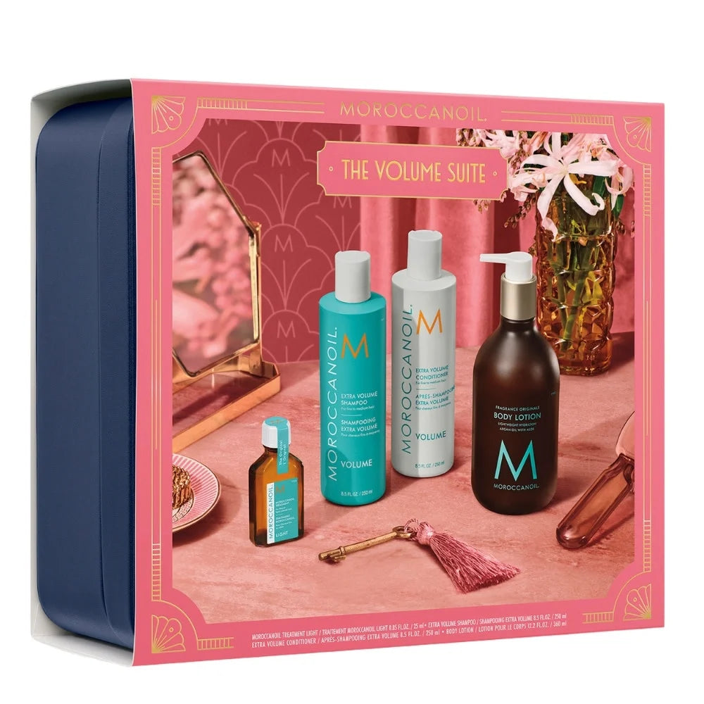 Moroccanoil The Volume Suite gift set in a navy blue tin with a pink illustrated front panel showing severalMoroccanoil haircare bottles and containers.