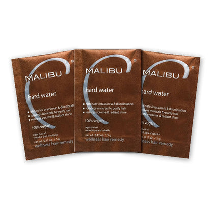 Three Malibu hard water wellness hair remedy packets on a white background