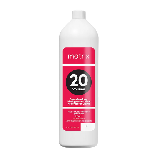 A white plastic bottle of Matrix 20 Volume Cream Developer with a white cap and a pink and black label, shown on a solid white background.