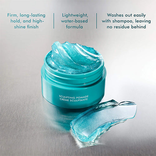 Blue moroccanoil sculpting pomade jar with a spoonful of pomade on a gray background