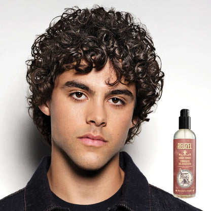 Man with styled hair next to a bottle of Reuzel product on a white background