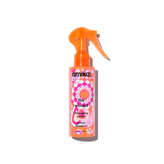 Amika hair product spray bottle with colorful label on a white background