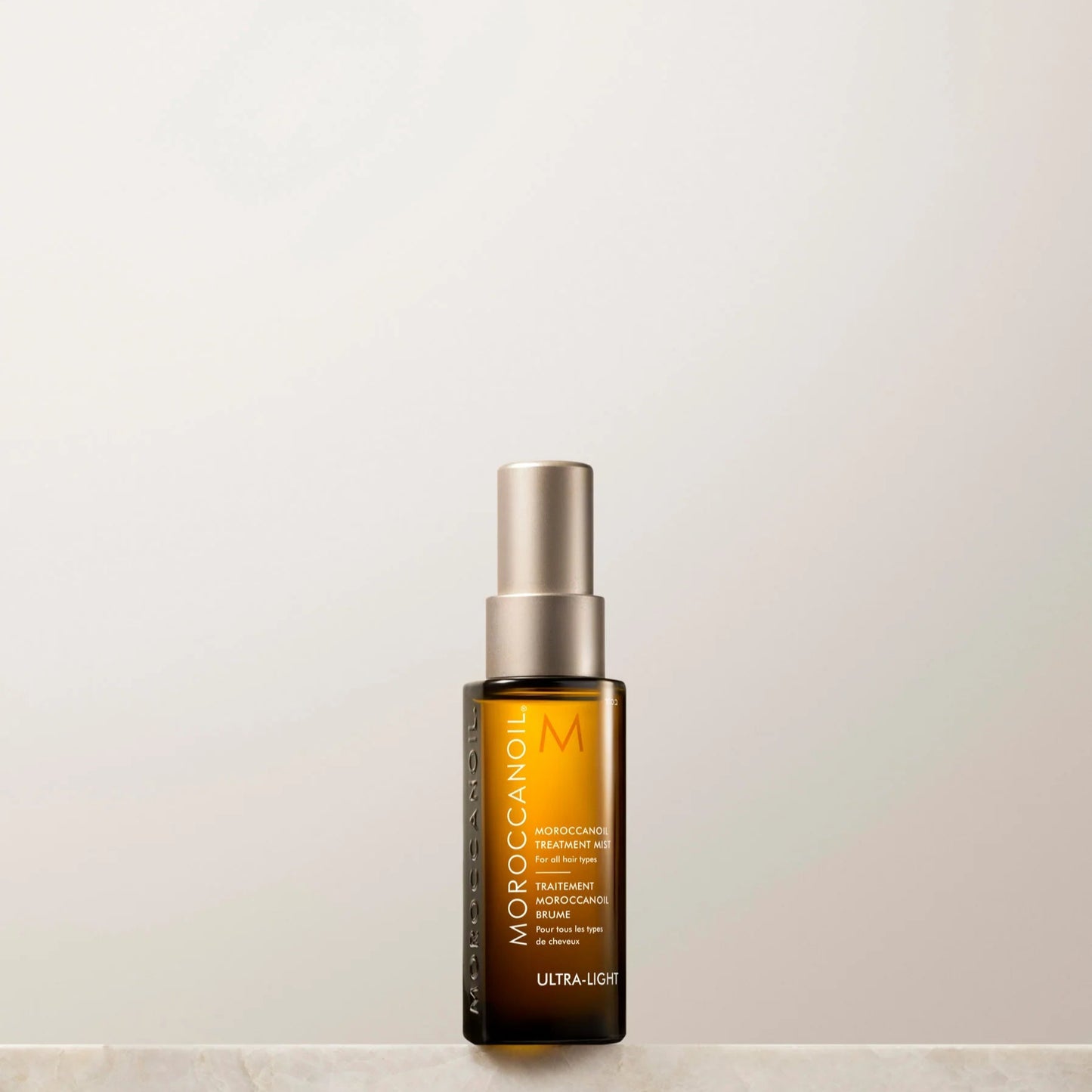 Skincare bottle labeled 'Moroccanoil' on a light background