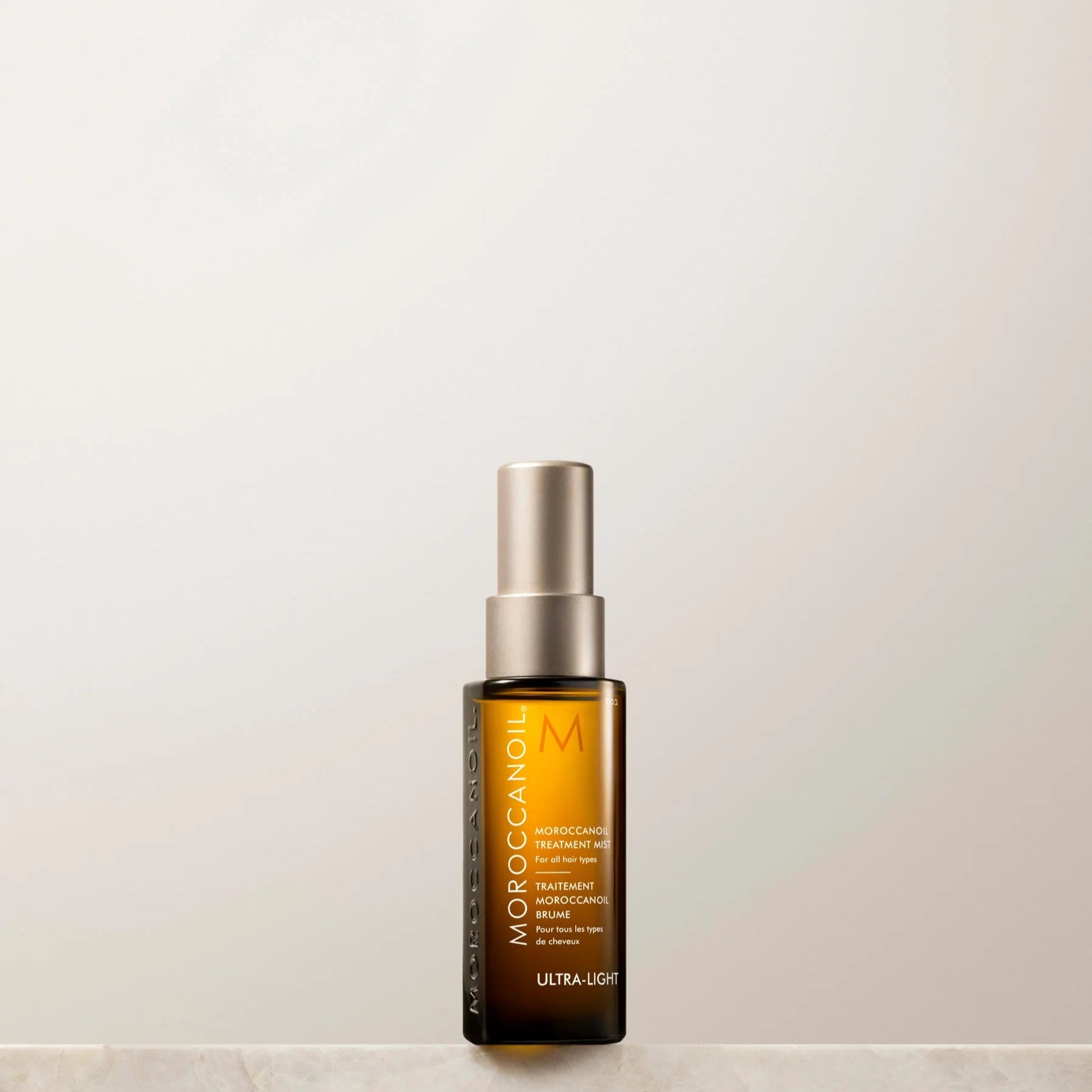 Skincare bottle labeled 'Moroccanoil' on a light background