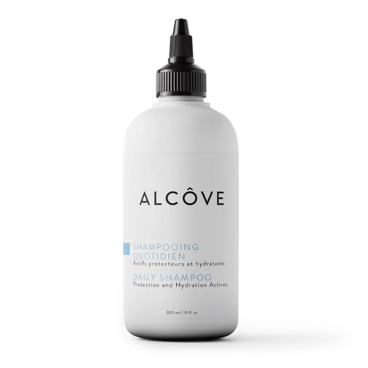 A white bottle of Alcôve Daily Shampoo with a black dropper cap, centered on a clean white background.