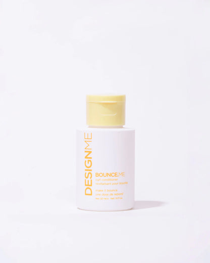 Designme bounceme conditioner travel bottle with yellow cap and white body on a light gray background
