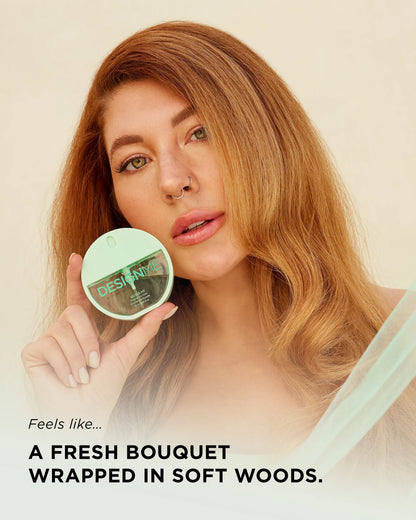 A woman with long highlighted brown hair holds up a round cosmetic jar with a mint green lid. The image has text overlays reading 'Feels like.