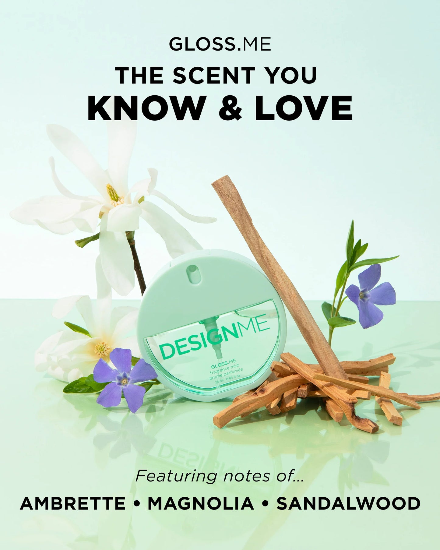 A round mint-green perfume bottle labeled 'DESIGN ME' is styled with white flowers, purple blossoms, and sandalwood pieces on a pale mint background. Text at the top reads 'GLOSS.