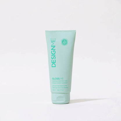 Mint green tube of DESIGNME hair product on a white background