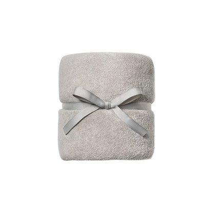 A folded light gray terry cloth towel wrapped with a matching gray ribbon bow, centered on a plain white background.