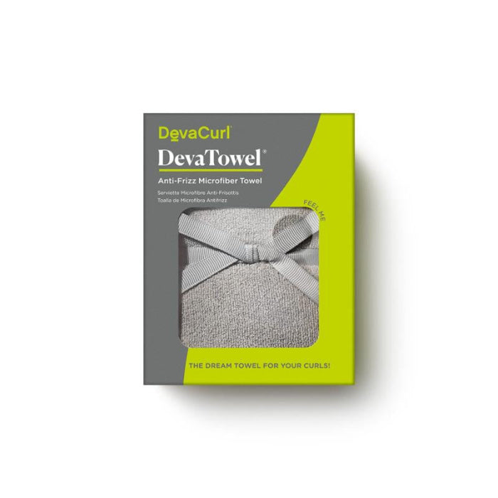 A boxed DevaCurl DevaTowel Anti-Friz Microfiber Towel shown on a white background. The retail package is gray and bright yellow-green, with a window revealing a light gray towel tied in a bow.