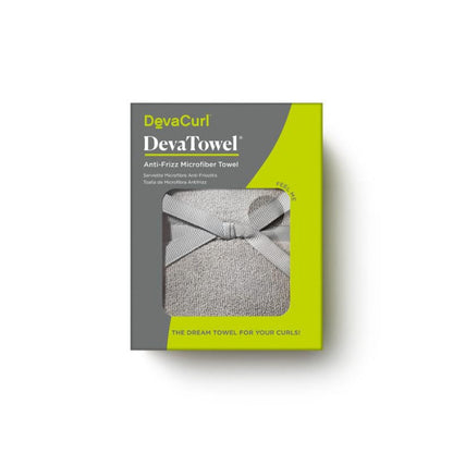 A boxed DevaCurl DevaTowel Anti-Friz Microfiber Towel shown on a white background. The retail package is gray and bright yellow-green, with a window revealing a light gray towel tied in a bow.