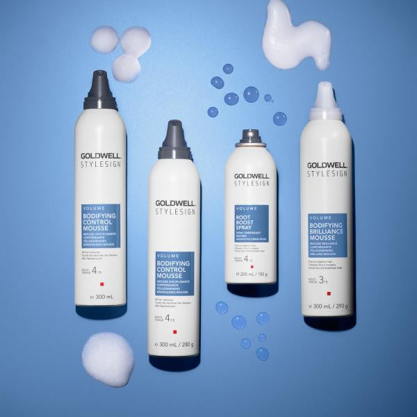 Goldwell hair care products on a blue background with foam elements.