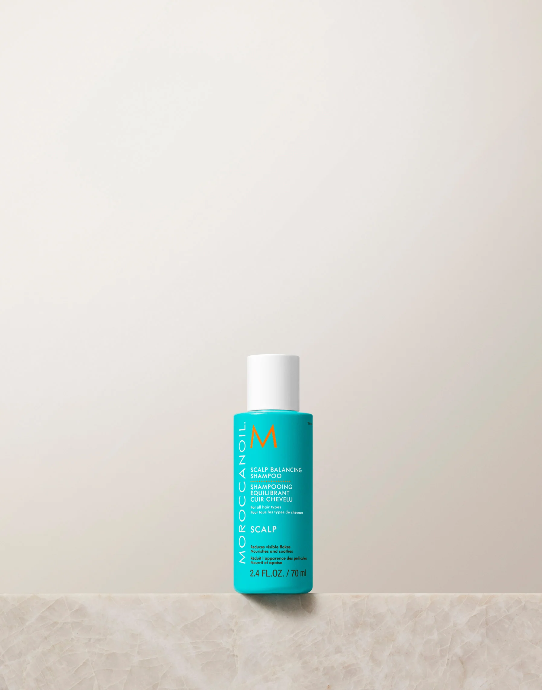 Moroccanoil bottle on a light beige background
