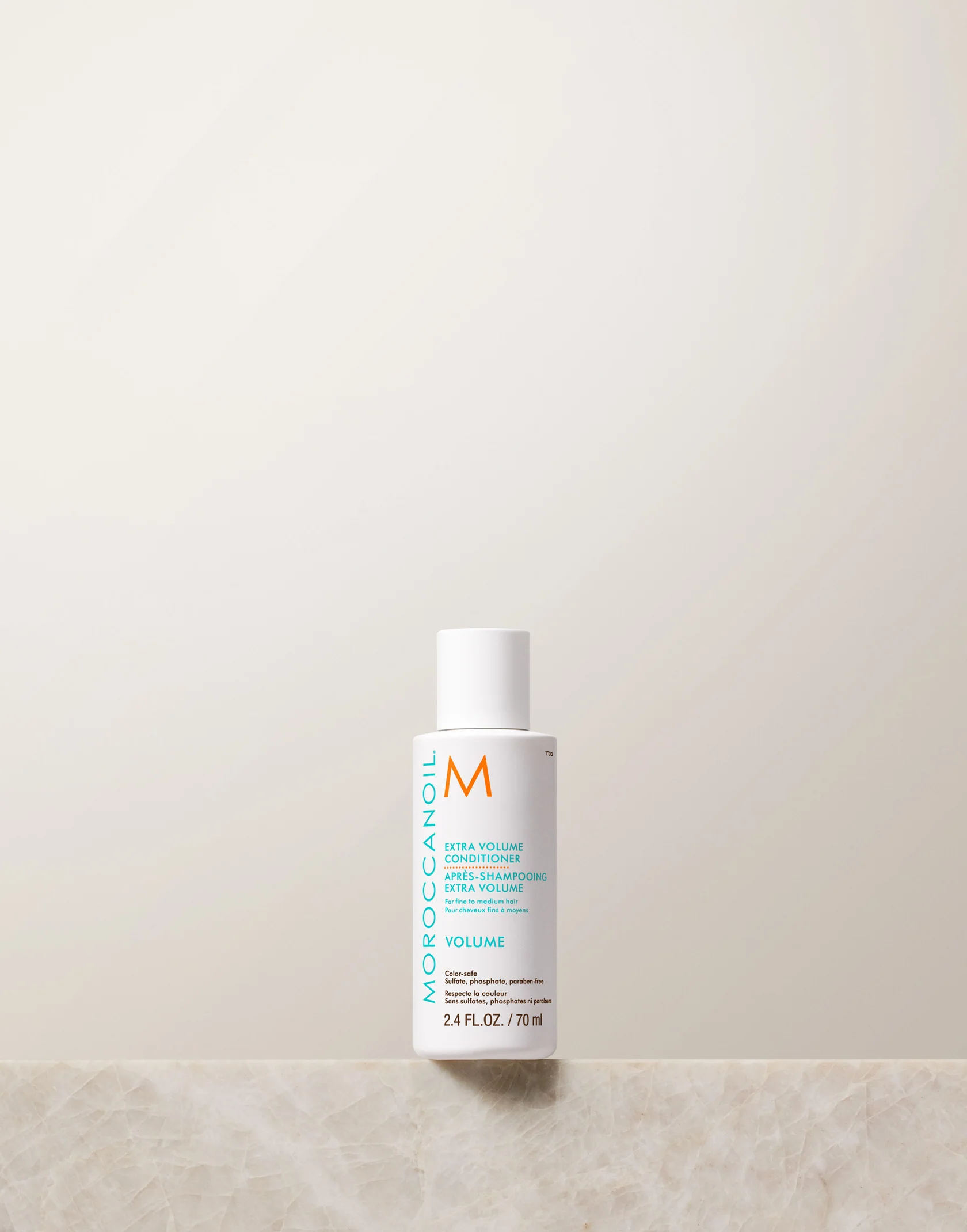 Moroccanoil bottle on a light beige background