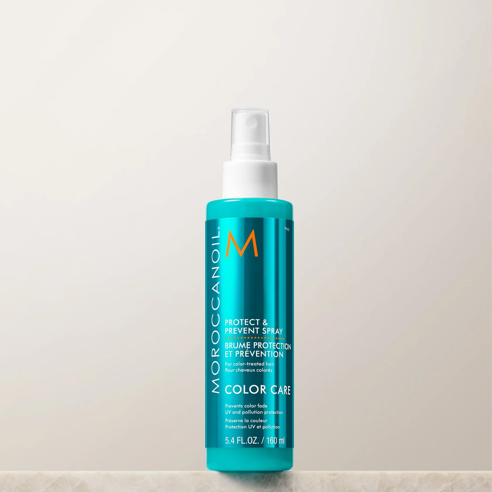 Moroccanoil bottle on a light beige background