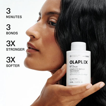 Woman holding an Olaplex hair treatment bottle with product benefits text on a white background
